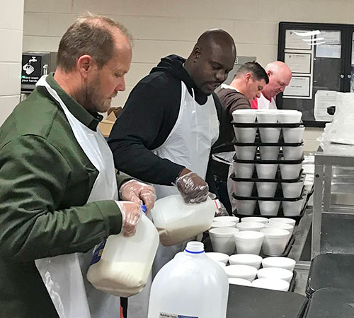 Remnant Fellowship members getting milk ready for breakfast at the Nashville Rescue Mission